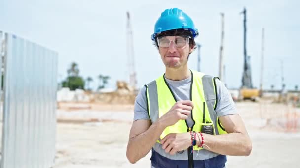 Молодой латиноамериканец архитектор улыбается уверенно стоя на месте строительства - Кадры, видео
