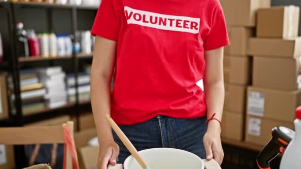 Młoda blondynka wolontariuszka uśmiecha się pewnie stojąc w centrum charytatywnym - Materiał filmowy, wideo