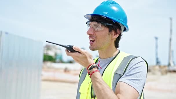 Mladý hispánský muž architekt mluví na vysílačce na staveništi - Záběry, video