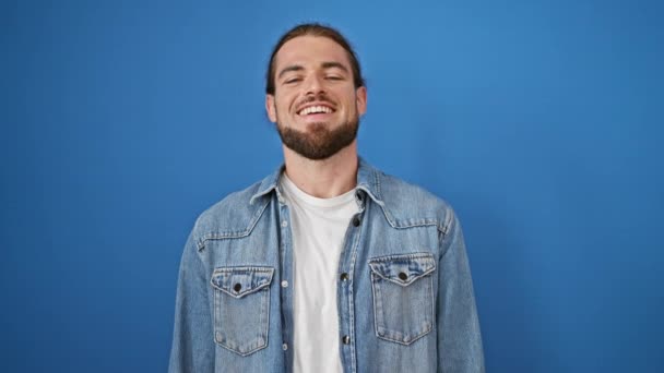Mladý hispánec muž usměvavý sebevědomě stojící nad izolované modré pozadí - Záběry, video