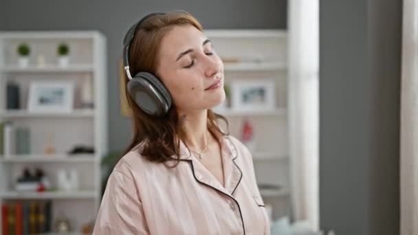 Fiatal nő zenét hallgat a hálószobában. - Felvétel, videó