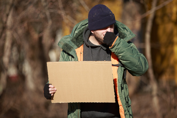 Homeless man holds blank cardboard for your own text - Foto, Imagen