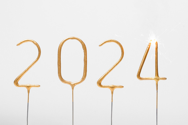Altın sayılar 2024 ve gri izole arka planda yanan 4 numaralı maytap. Yeni yılı kutlamak, eskisini bitirmek, selamlar ve dilekler. - Fotoğraf, Görsel