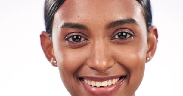 Indiase vrouw, gezicht en studio close-up voor glimlach, schoonheid en trots met wellness door witte achtergrond. Meisje, model en zoom van gezichtshuid met cosmetica, transformatie of natuurlijke glans in portret. - Video