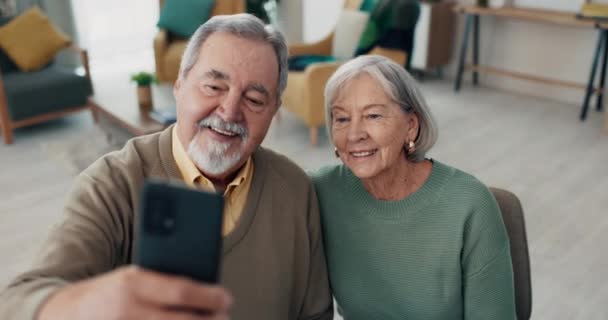 Ζευγάρι ηλικιωμένων, selfie και χαμόγελο στο σπίτι για blog, post ή μνήμη με ρομαντισμό, αγάπη και δέσιμο κατά τη συνταξιοδότηση. Γέρος, ηλικιωμένη γυναίκα και χαρούμενος για φωτογραφία προφίλ, φωτογραφία ή εφαρμογή κοινωνικού δικτύου. - Πλάνα, βίντεο