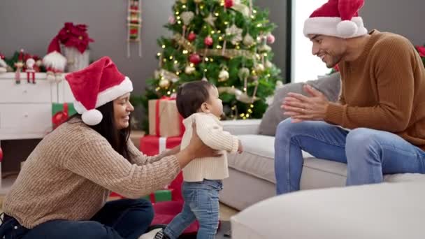 Ζευγάρι και γιος περπατούν δίπλα στο χριστουγεννιάτικο δέντρο στο σπίτι - Πλάνα, βίντεο
