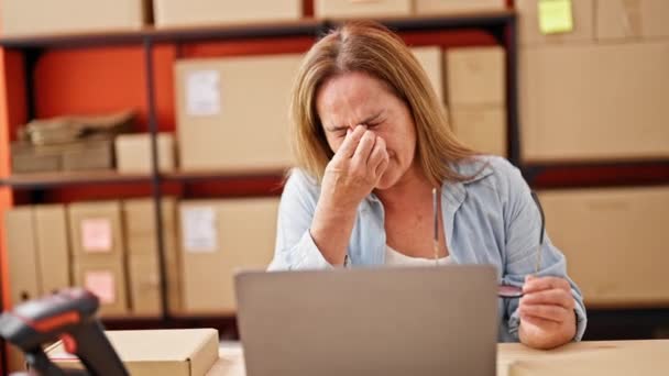 Latynoska kobieta w średnim wieku e-commerce business worker using laptop tired at office - Materiał filmowy, wideo