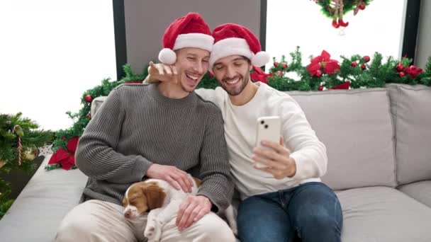 Dwóch mężczyzn świętuje Boże Narodzenie podczas rozmowy wideo w domu - Materiał filmowy, wideo