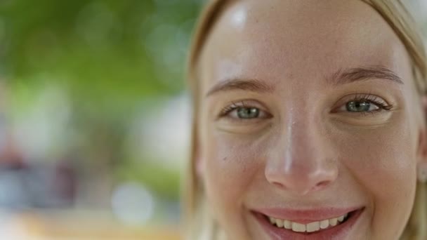Nuori blondi nainen hymyilee luottavainen seisoo puistossa - Materiaali, video