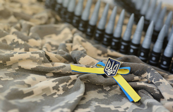 Украинский символ и пулемётный пояс на камуфляжной форме украинского солдата. Концепция войны в Украине, патриотизм и защита своей страны от российских оккупантов - Фото, изображение