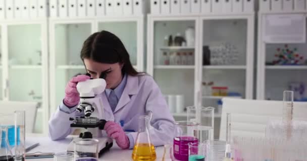 Επιστήμονας φοιτητής σκέψης, εστιάζοντας στις αμφιβολίες, εξετάζει μικροσκόπιο. Πρόβλημα στην ιατρική ή χημική έρευνα - Πλάνα, βίντεο