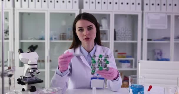 Mulher cientista ou estudante segurando modelo de estrutura molecular em laboratório. Conceito de educação científica e pesquisa química - Filmagem, Vídeo