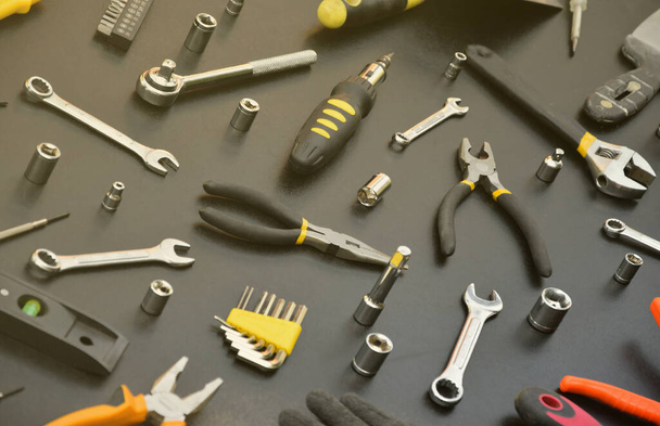Kit de herramientas Handyman sobre mesa de madera negra. Muchas llaves y destornilladores, pilotes y otras herramientas para cualquier tipo de reparación o construcción. Reparador herramientas conjunto - Foto, Imagen