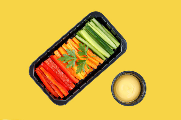 Paprika-Karotten und Gurken in Streifen auf gelbem Hintergrund schneiden - Foto, Bild