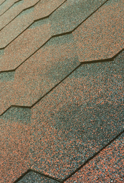 The texture of the roof with bituminous coating. Rough bituminous mosaic of red and brown flowers. Waterproof roofing - Photo, Image