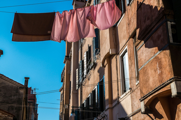 Ενδύματα που κρεμούν να στεγνώσει σε έναν παραδοσιακό δρόμο της Βενετίας - Φωτογραφία, εικόνα