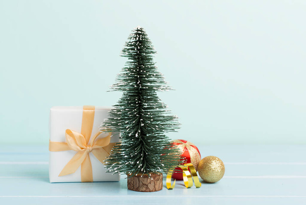 Miniatűr karácsonyfa ajándékdobozokkal és dekorációval az asztalon - Fotó, kép
