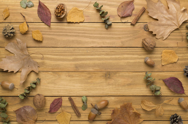 Φθινοπωρινά φύλλα με διακόσμηση σε ξύλινο φόντο, top view - Φωτογραφία, εικόνα