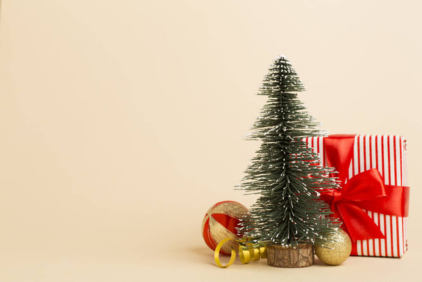 Миниатюрная елка с подарочными коробками и декором на столе - Фото, изображение