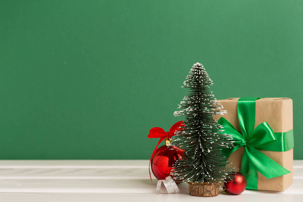 Miniatuur kerstboom met geschenkdozen en decoratie op tafel - Foto, afbeelding