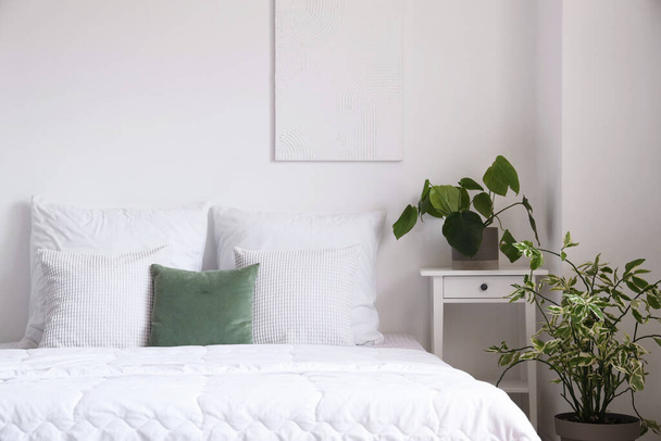 Acogedora cama con manta blanca y almohadas en dormitorio luminoso - Foto, imagen