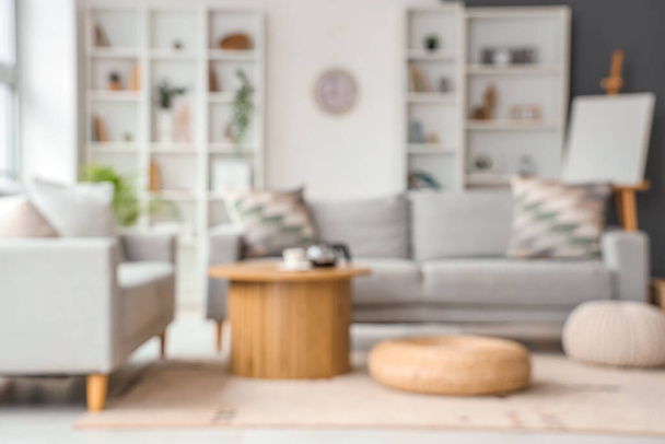 Rozmazaný pohled na obývací pokoj s pohovkami, stolem a brašnami - Fotografie, Obrázek