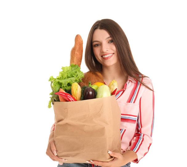 Mladá žena drží papírový sáček s čerstvou zeleninou na bílém pozadí - Fotografie, Obrázek