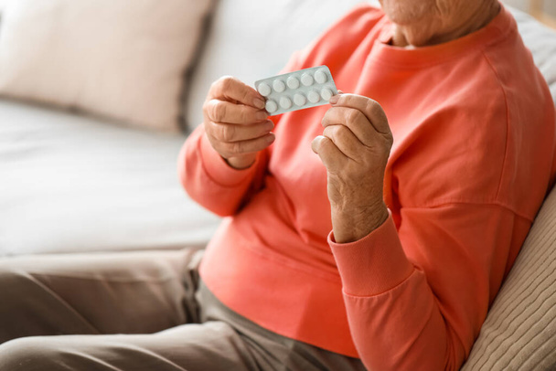 Mujer mayor con pastillas en casa, primer plano
 - Foto, Imagen