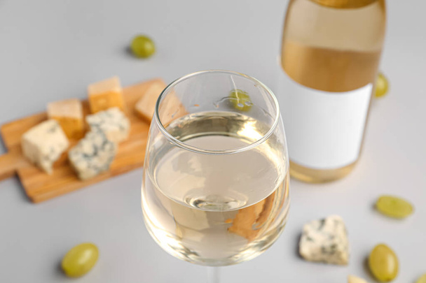 Glas smakelijke wijn op lichte achtergrond, close-up - Foto, afbeelding