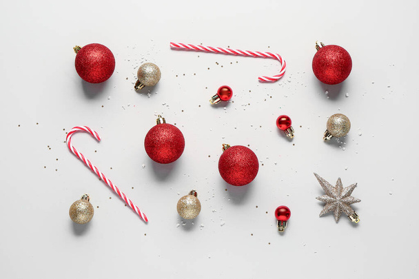 Σύνθεση με Χριστουγεννιάτικες μπάλες και νόστιμες καραμέλες σε ελαφρύ φόντο - Φωτογραφία, εικόνα