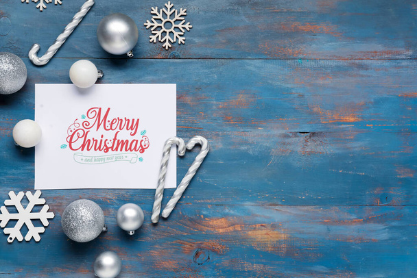 Красивая рождественская композиция с поздравительной открыткой и декором на синем деревянном фоне - Фото, изображение