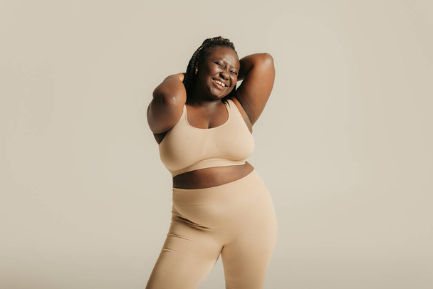 Joyful African plus size woman in underwear radiating love to her body on studio background - Fotoğraf, Görsel