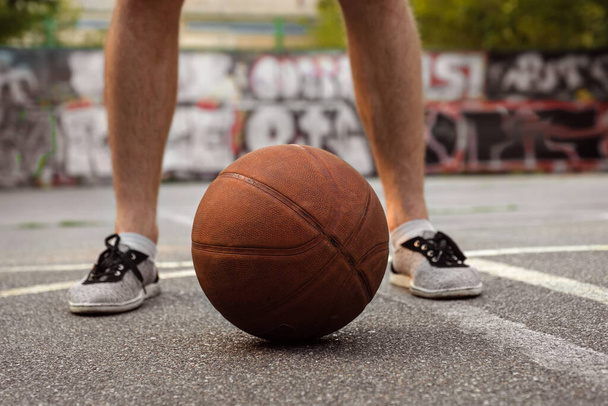 Young man playing with a basketball outdoors. Active lifestyle concept. - Фото, зображення