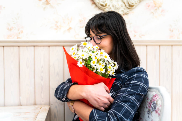 mladá žena s květinami v kavárně - Fotografie, Obrázek