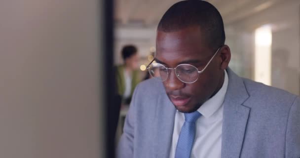 Számítógép, arc és üzlet fekete férfival és szemüveggel az irodában kutatásra vagy problémamegoldásra. Technika, rámutatás és tervezés afrikai férfi alkalmazott olvasási információk online adatelemzés. - Felvétel, videó