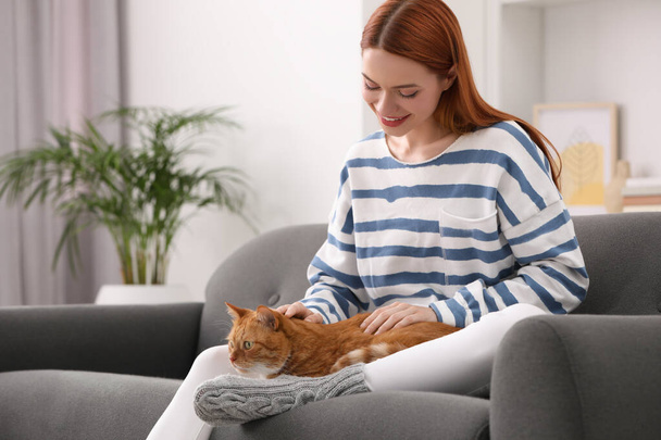 Счастливая женщина со своей милой кошкой на диване дома - Фото, изображение