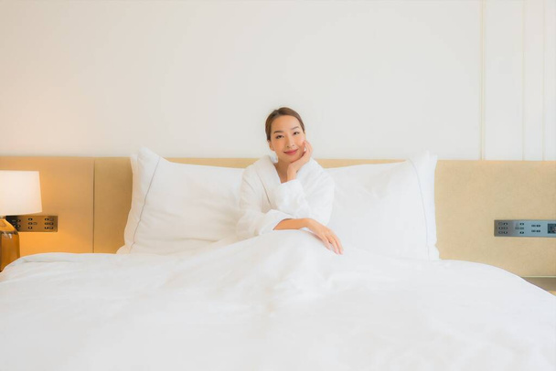 retrato hermosa joven asiática mujer relax sonrisa ocio en cama en dormitorio interior - Foto, imagen