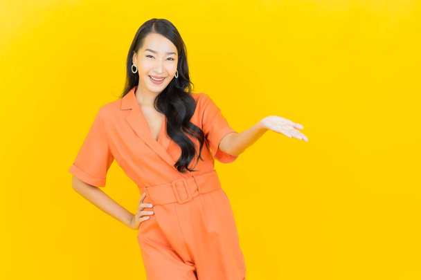 Portrait beautiful young asian woman smile with action on yellow color background - Fotografie, Obrázek