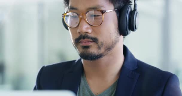 Music headphones, business man and lens flare in office working on project. Radio, listening and professional Asian person streaming audio, podcast or sound while reading, serious or focus on project. - Footage, Video