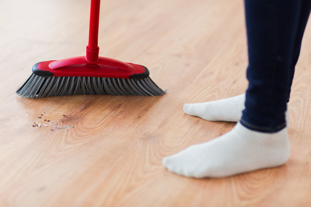 close up of woman legs with broom sweeping floor - Фото, зображення