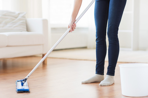 close up of woman with mop cleaning floor at home - Фото, изображение
