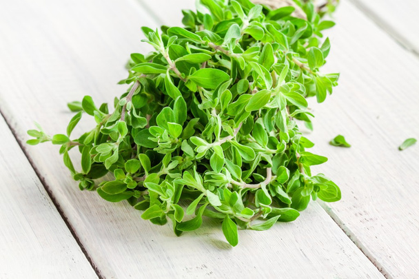bunch of raw green herb marjoram on a white  wooden table - Photo, Image