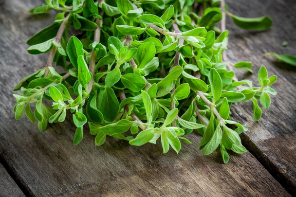 bunch of raw green herb marjoram on a wooden table - Photo, Image