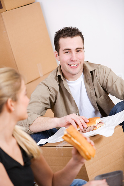 Verplaatsen: Paar neemt een pauze van verpakking met broodjes - Foto, afbeelding