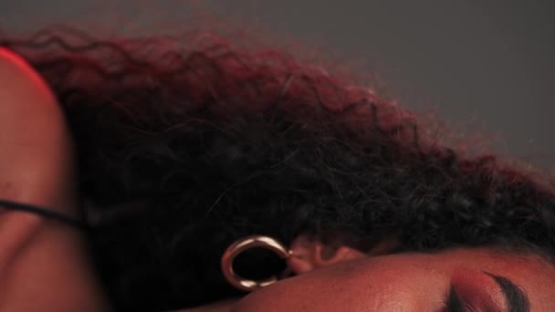 Ritratto di giovane donna swarthy con capelli afro-style e trucco luminoso. Rallentatore - Filmati, video
