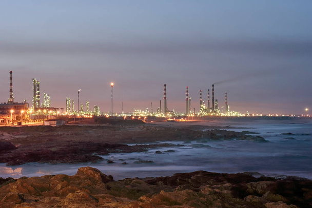 Gran refinería de petróleo junto al mar al amanecer - Foto, imagen