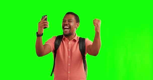 Telefon, cestování a zelená obrazovka s vítězem černochem ve studiu fandit za úspěch nebo dobré zprávy. Mobilní, motivace a wow s šťastný mladý muž batohem na oslavu na chromakey mockup. - Záběry, video