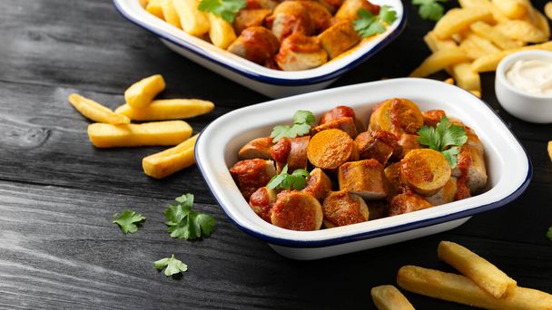 Traditional German currywurst, served with potato chips and sauce. - Photo, Image