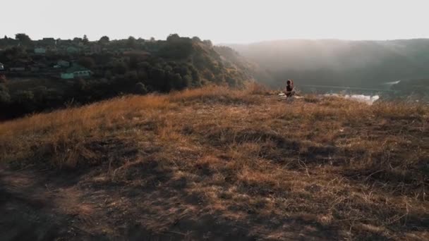 young fitness woman meditating on sunrise mountain peak. Drone footage 4k - Footage, Video
