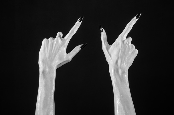 white hands of death with black nails, white death, the devil's hands, the hands of a demon, white skin, halloween theme, black background, isolated - Foto, afbeelding